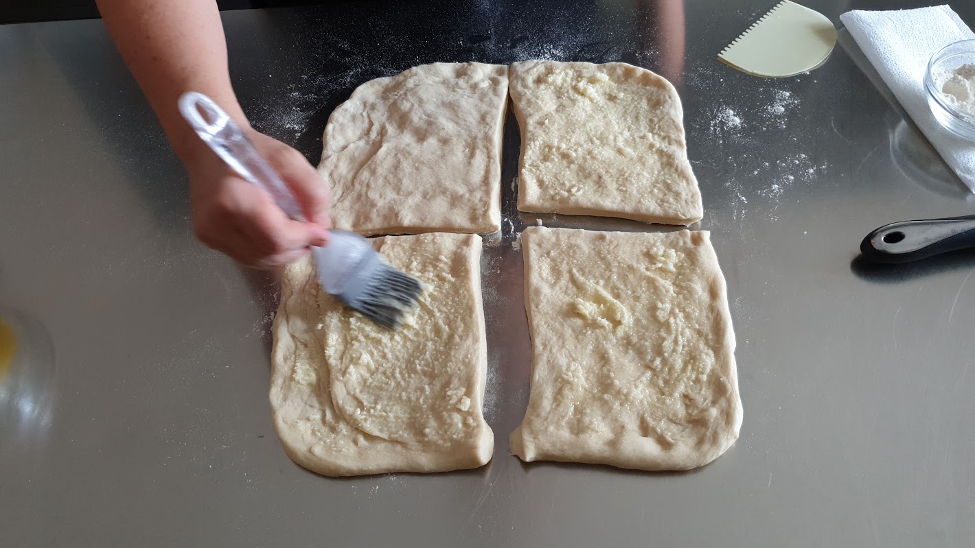Sfogliatura dell’impasto delle brioche con burro e zucchero